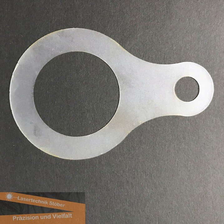 Dünnes Kunststoff- oder Dichtungsteil mit großem Innenkreis und kleinerem Loch – Beispiel für präzise Laserkontur