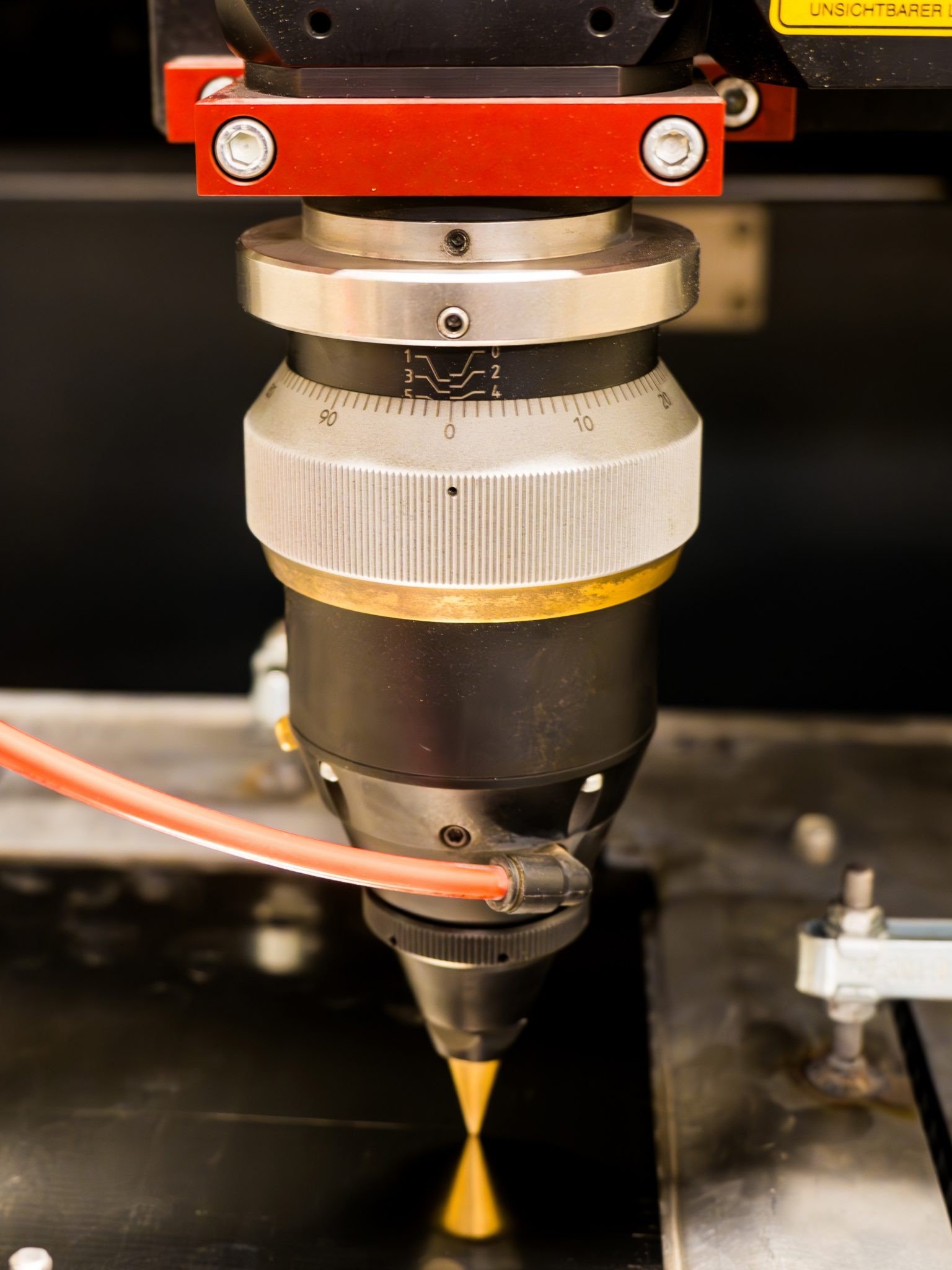Fokuslinse eines Laserfeinschneidkopfs bei der Bearbeitung von Blech