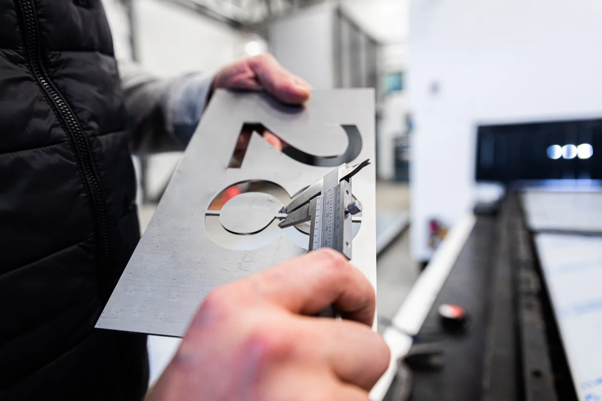 mitarbeiter-prueft-gelasertes-blechteil-mit-schieblehre-cnc-laserschneiden-mit-hoher-masshaltigkeit-1